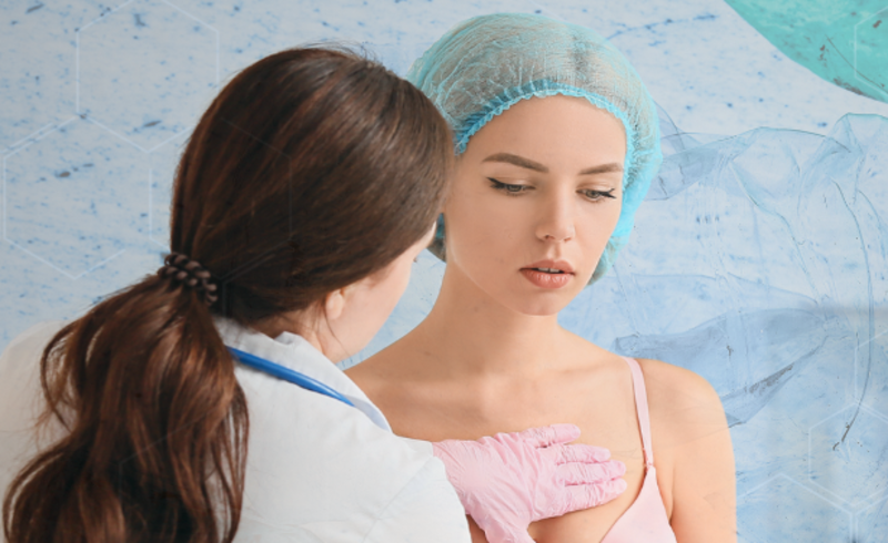 young woman with pink bra having breasts examined by doctor