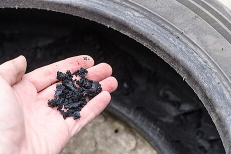 Hand holding crumb rubber made from old tires