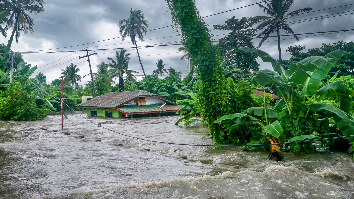 Rising water levels submerge a house as heavy monsoon rains cause flooding