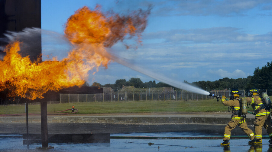 Air Force firefighters spraying down a fire